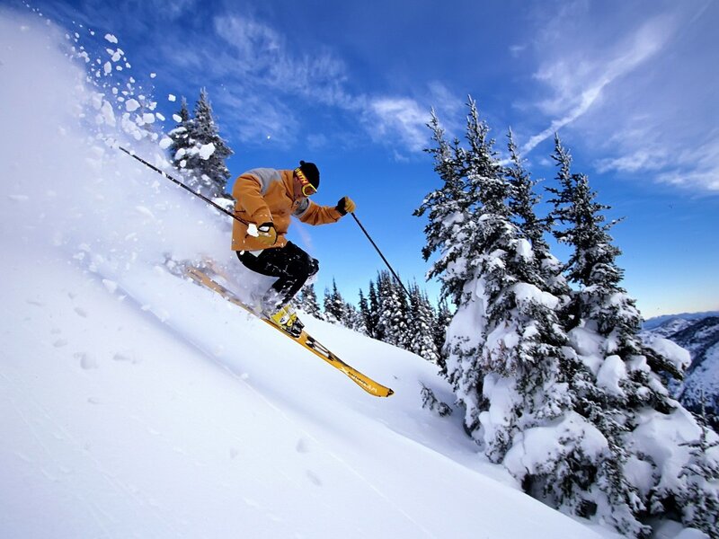 Skier carving down snowy slope