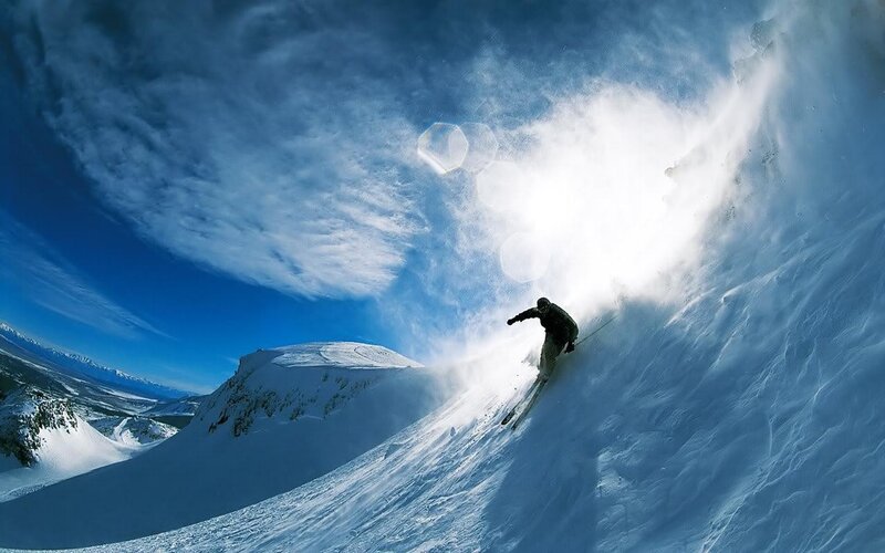 Skier carving down snowy slope