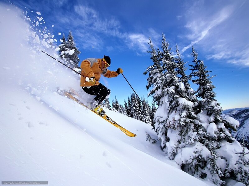 Skier carving down snowy slope