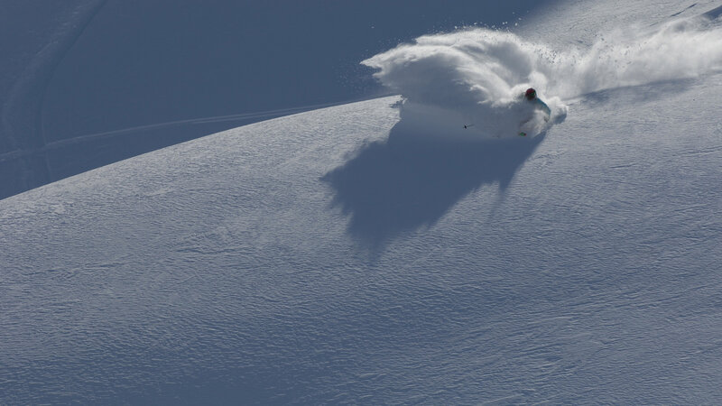 Skier carving on snowy slope