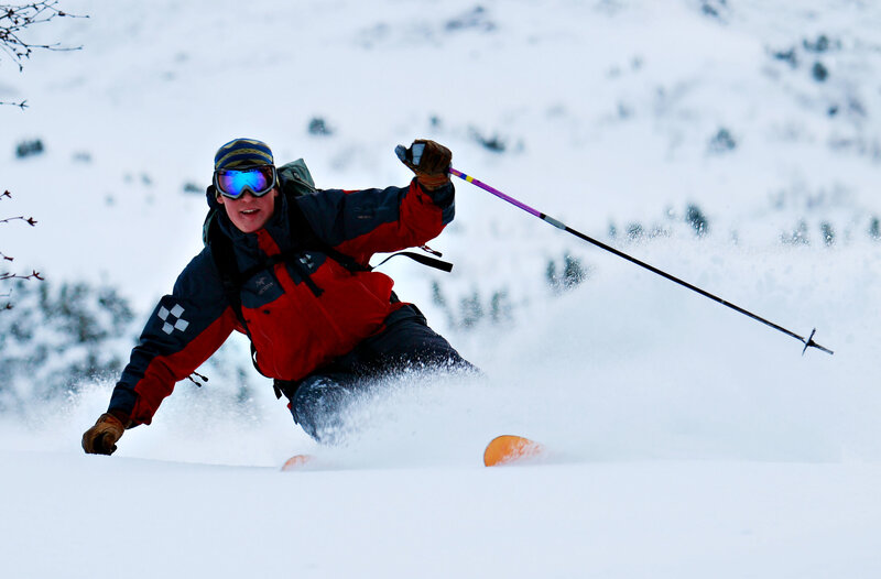 Skier carving through powder