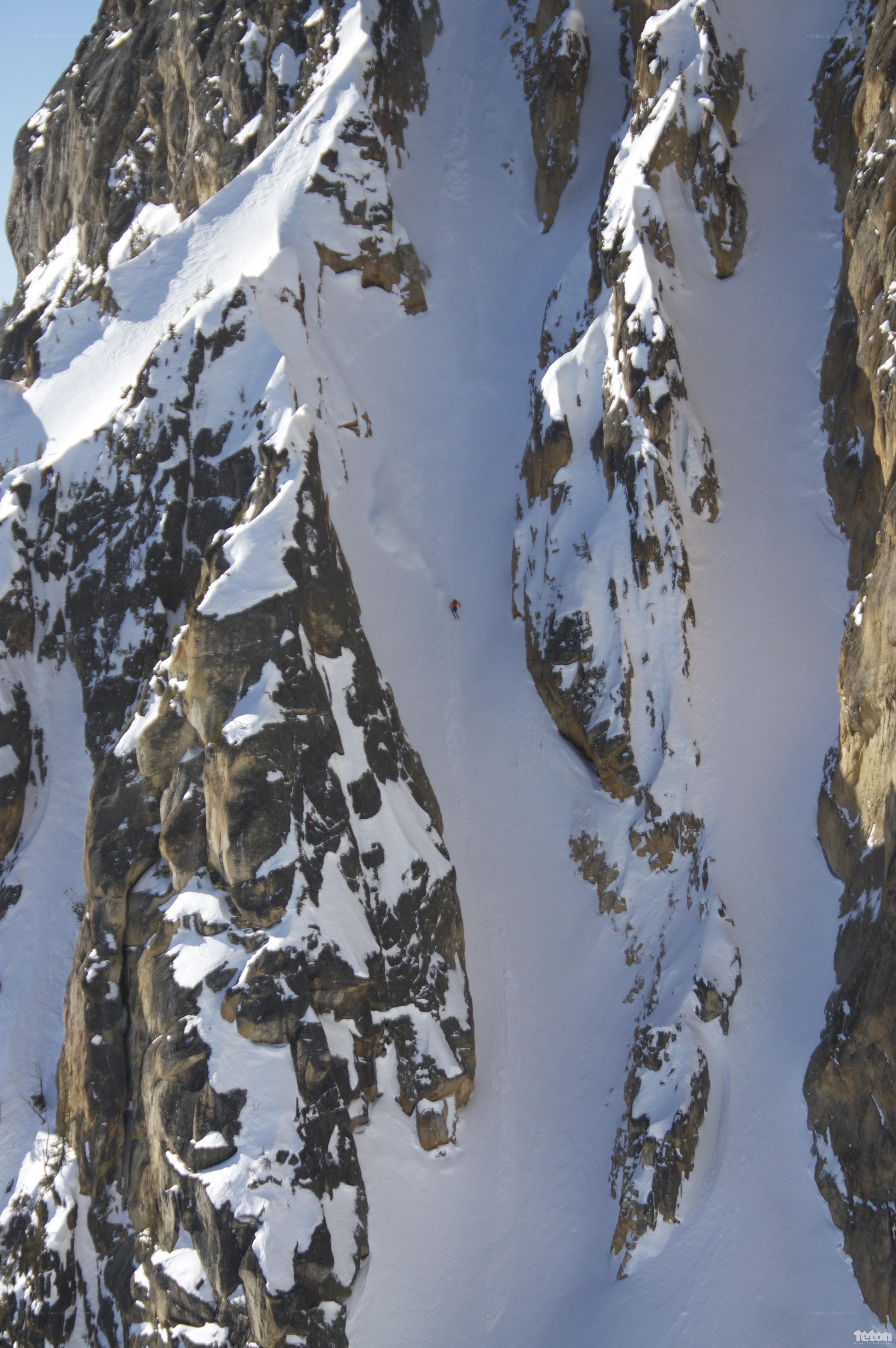 Skier descending a snowy canyon