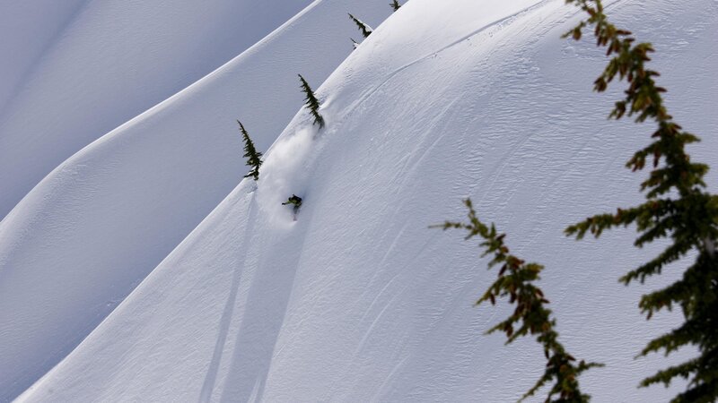 Skier descending snowy slope