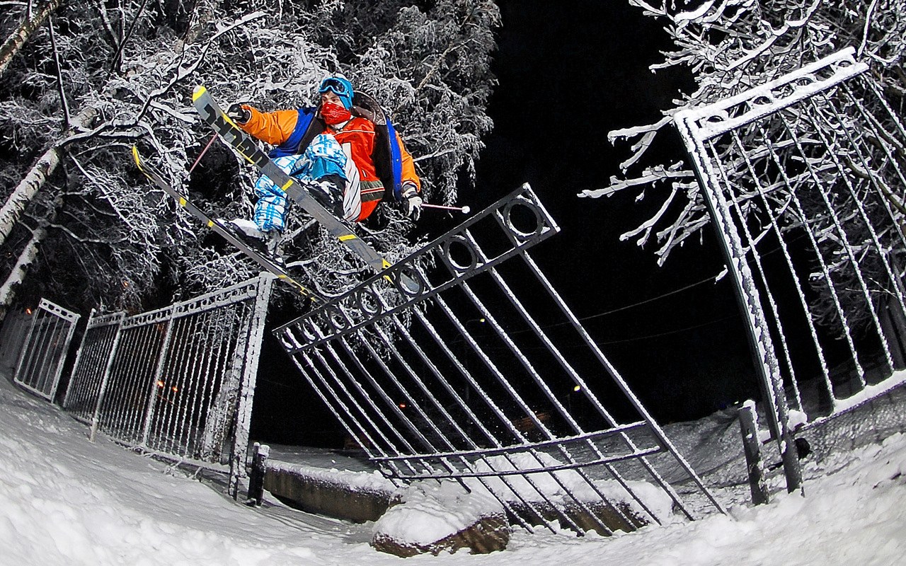 Skier jumping over fence