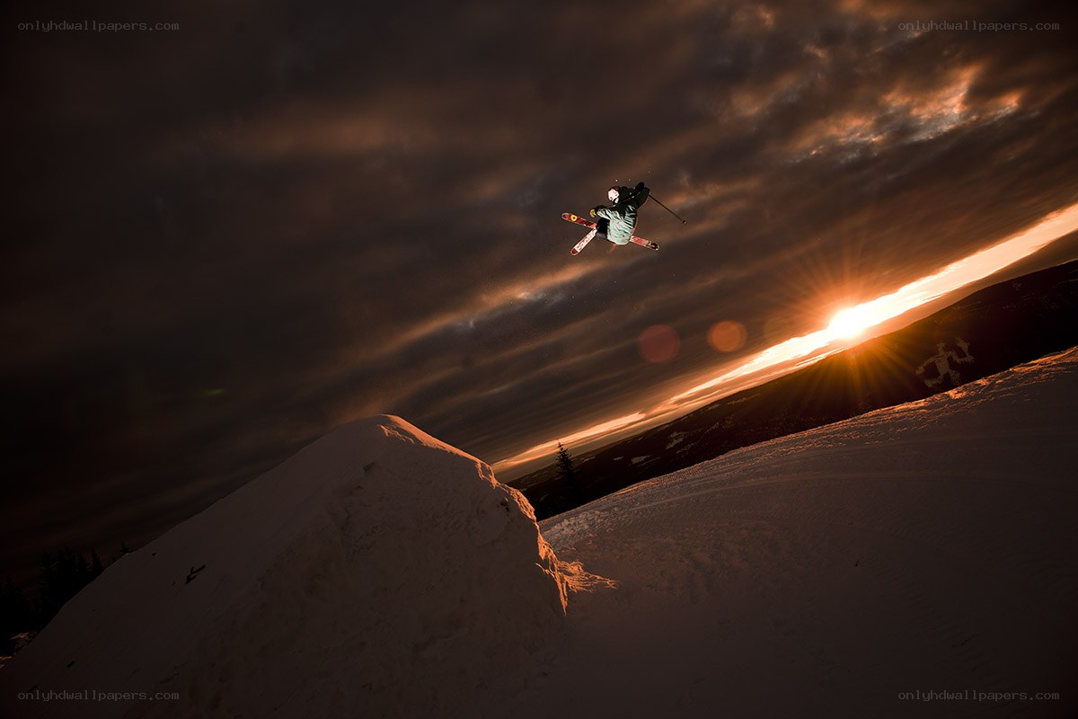 Skier mid-air jump at sunset