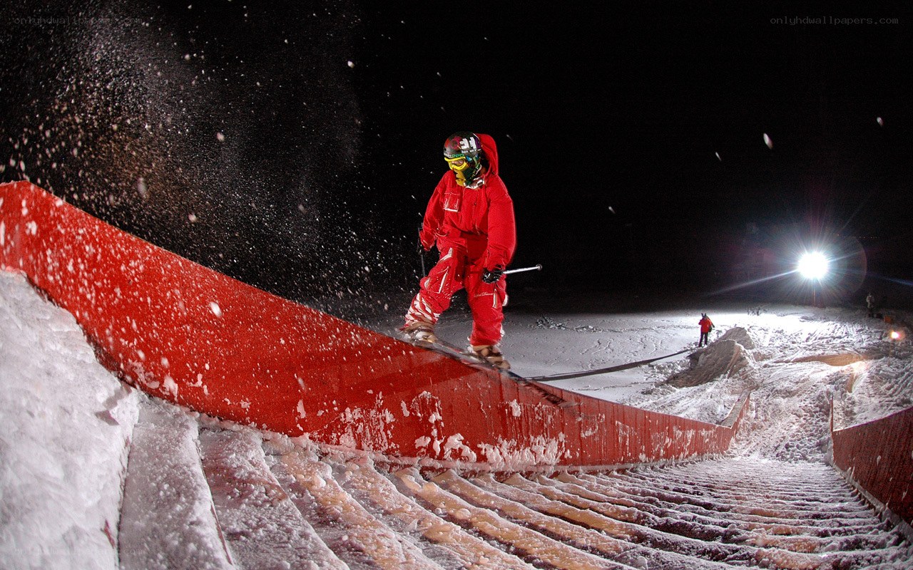 Skier on a red rail at night