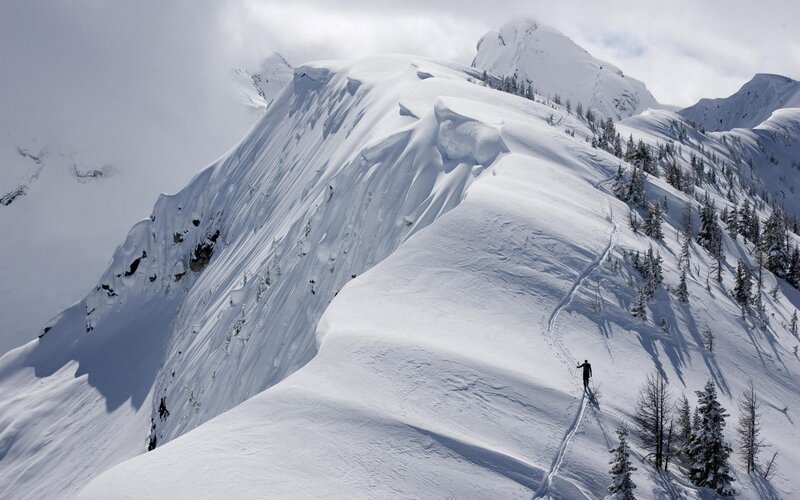 Skier on snowy mountain ridge
