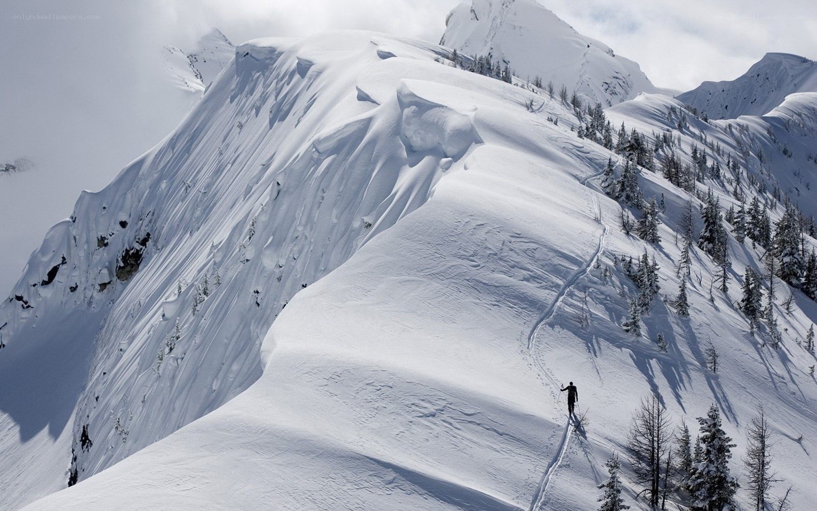 Skier on snowy mountain ridge