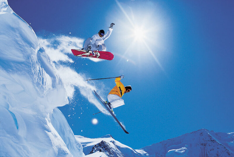Skiers and snowboarders in mid-air