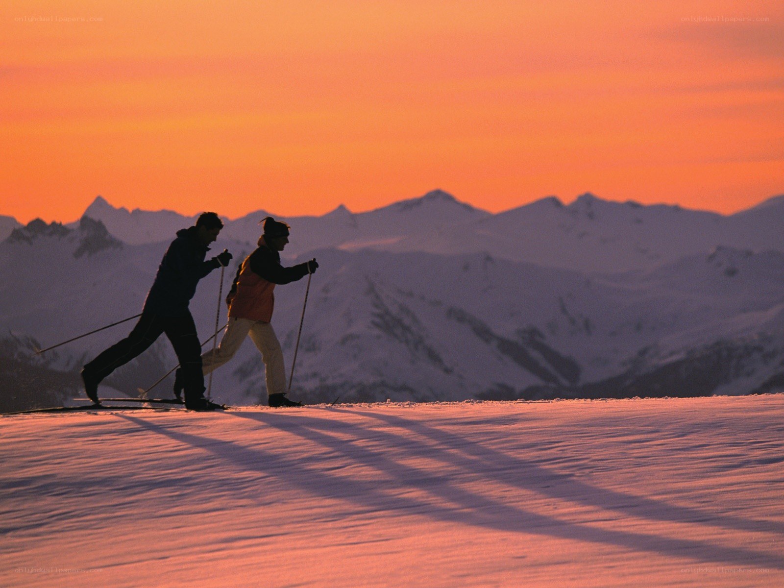 Skiers at sunset in the mountains