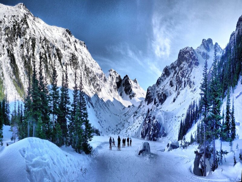 Skiers in snowy mountain valley