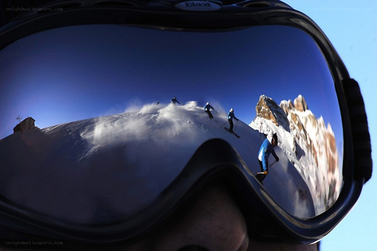 Skiers reflected in goggles
