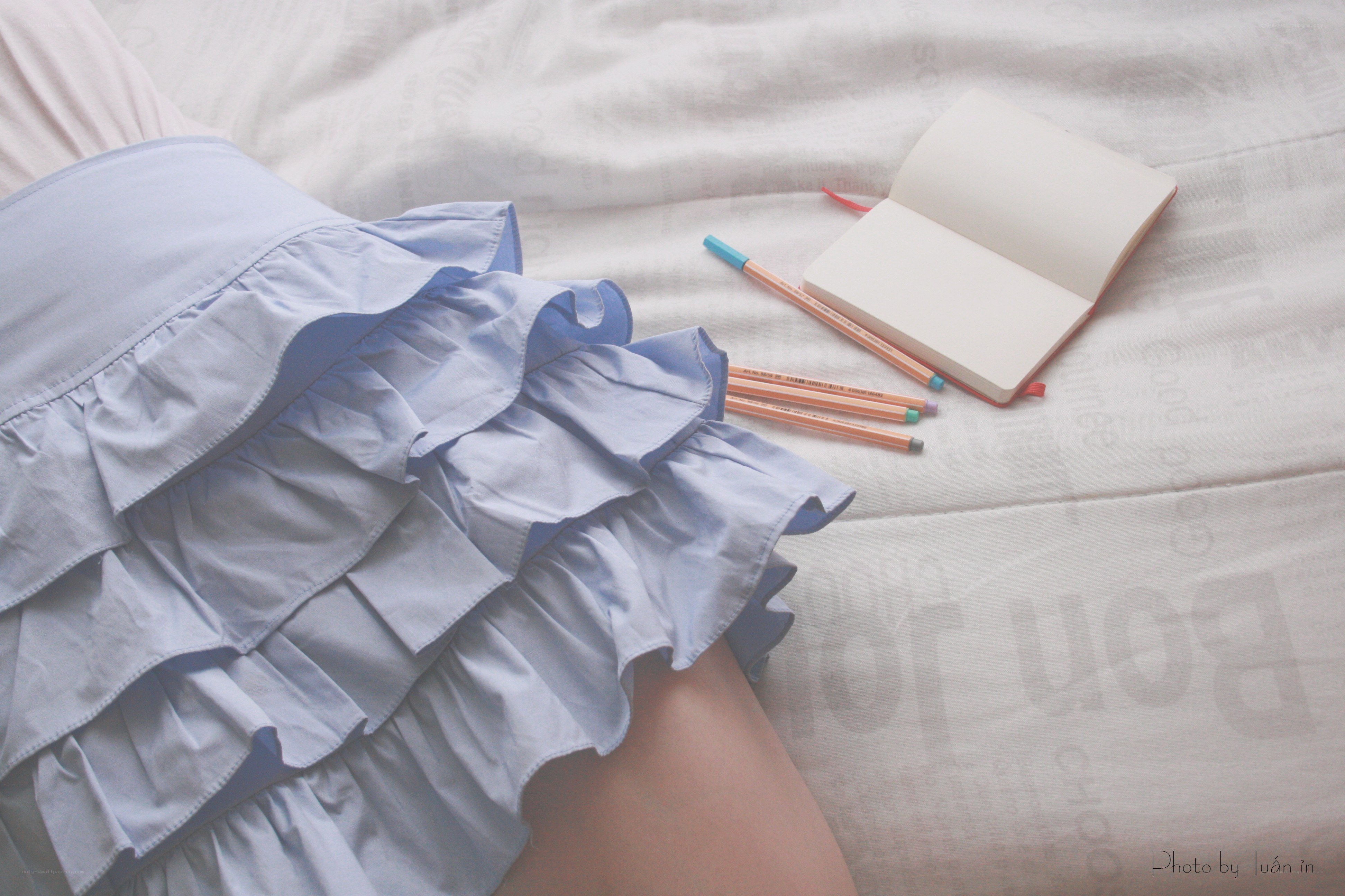 skirt and notebook on bed