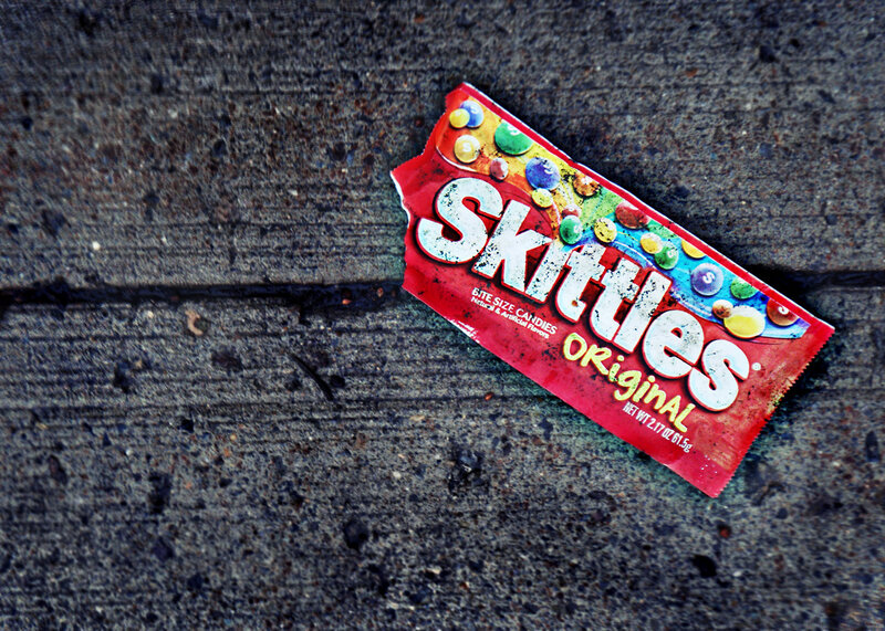 Skittles candy wrapper on pavement