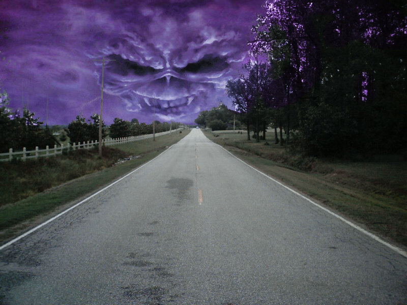 Skull-shaped clouds over a road