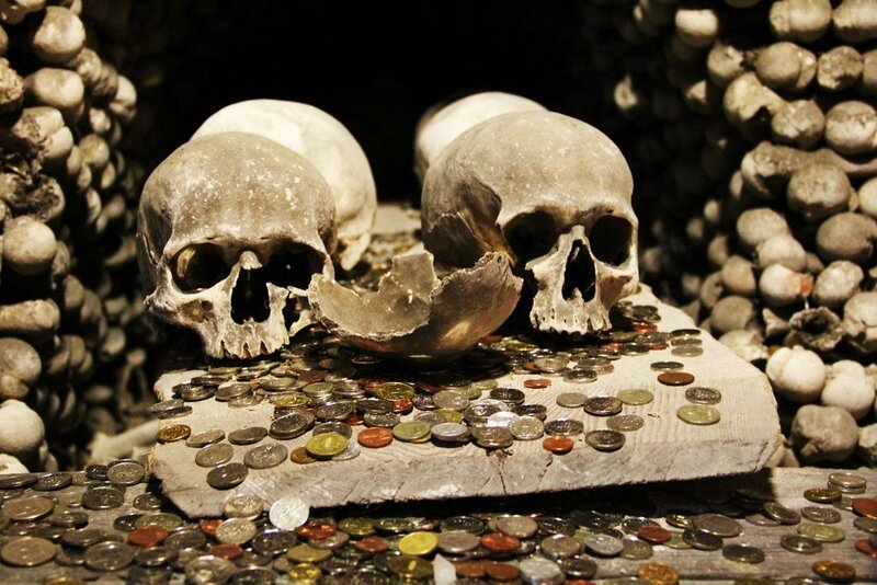 Skulls with coins in ossuary