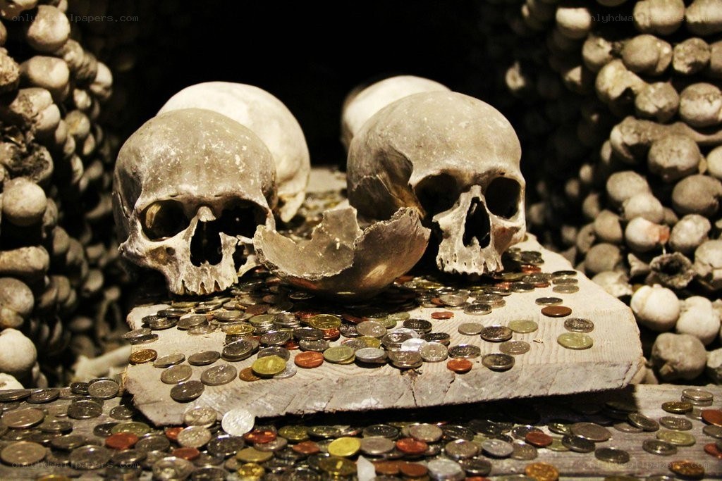 Skulls with coins in ossuary