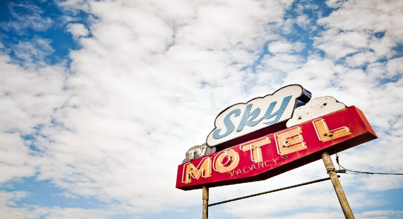 Sky Motel sign against cloudy sky