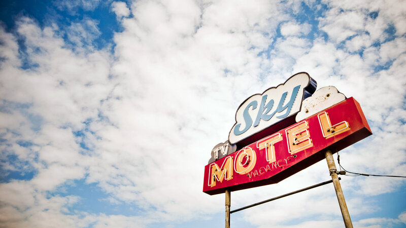 Sky Motel sign against cloudy sky