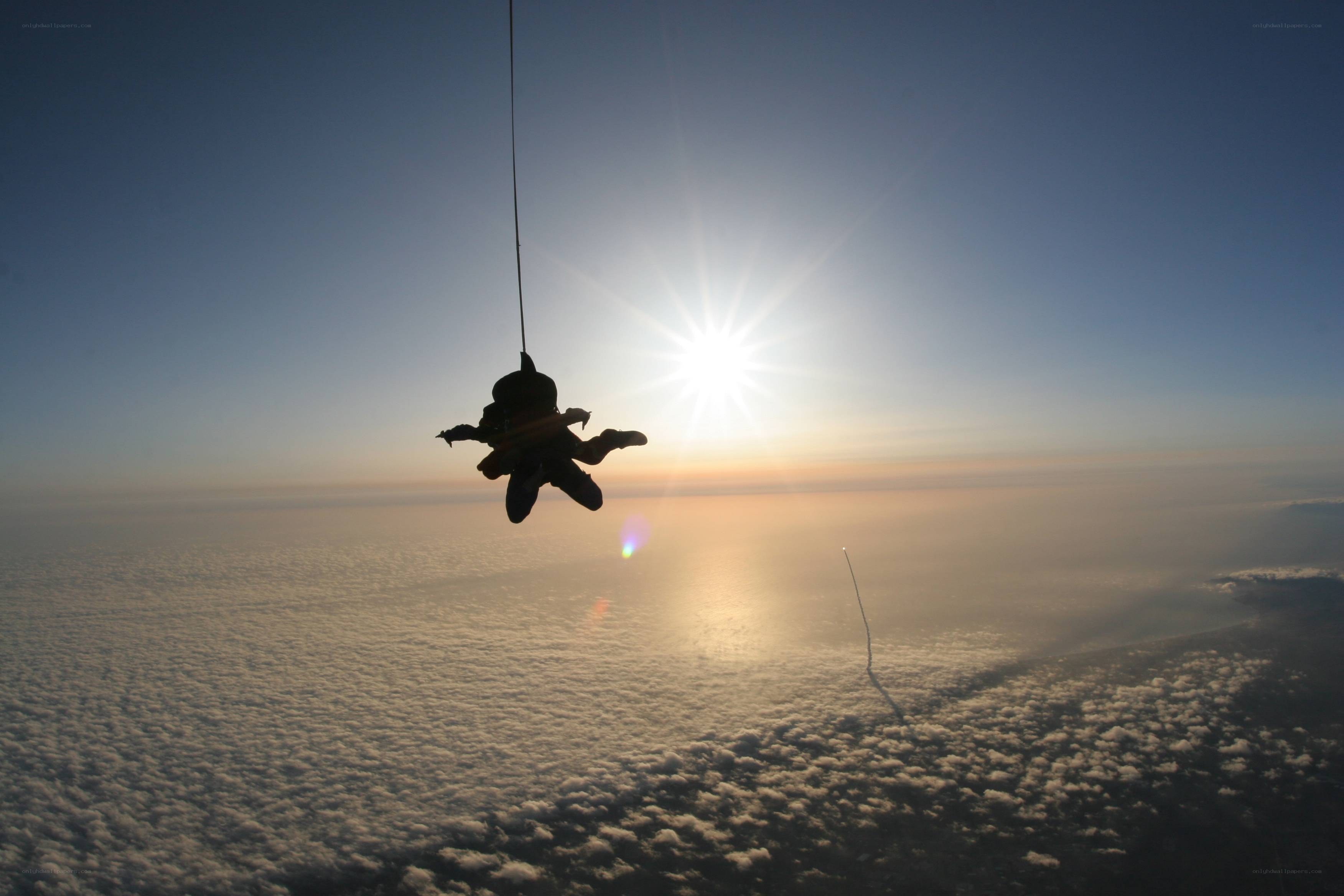 Skydiver above clouds at sunrise