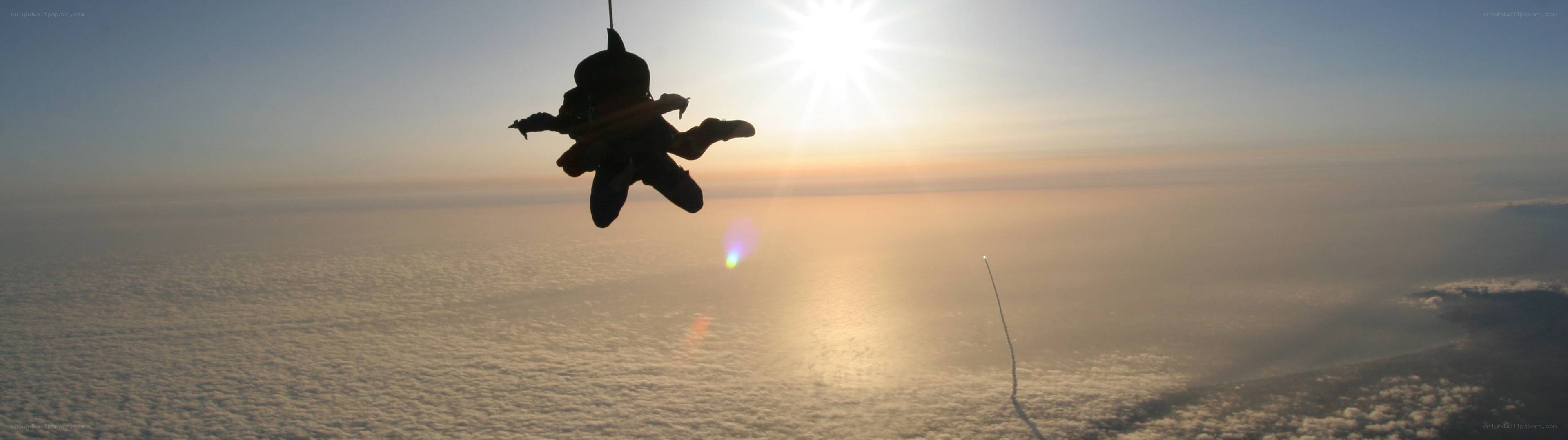 Skydiver in silhouette at sunset