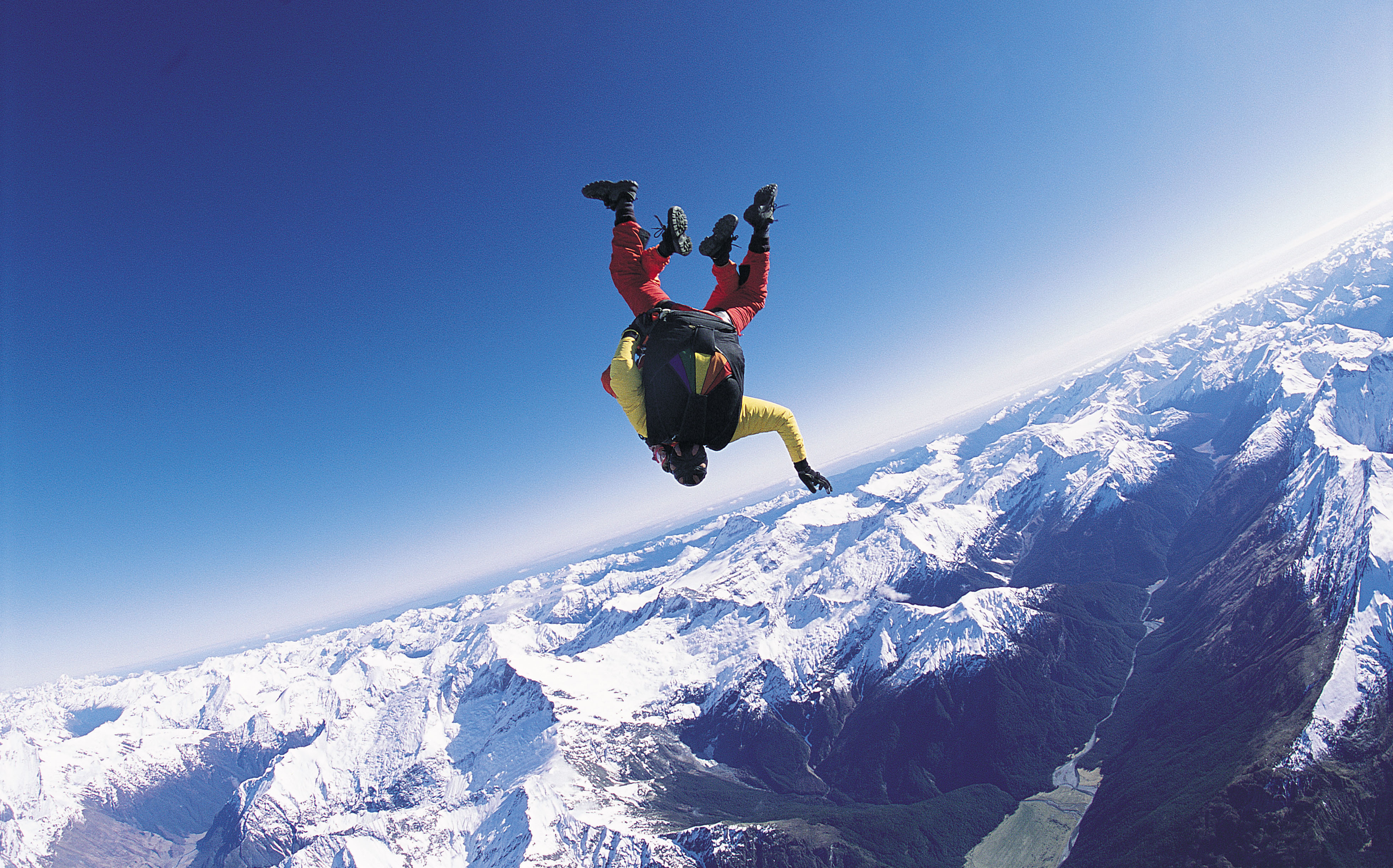 Skydiver over snowy mountains