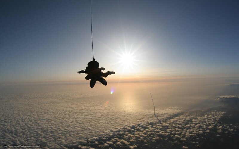 Skydiver silhouetted against sun