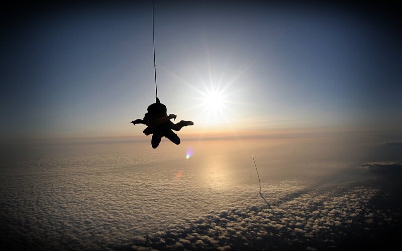 Skydiver silhouetted against the sun
