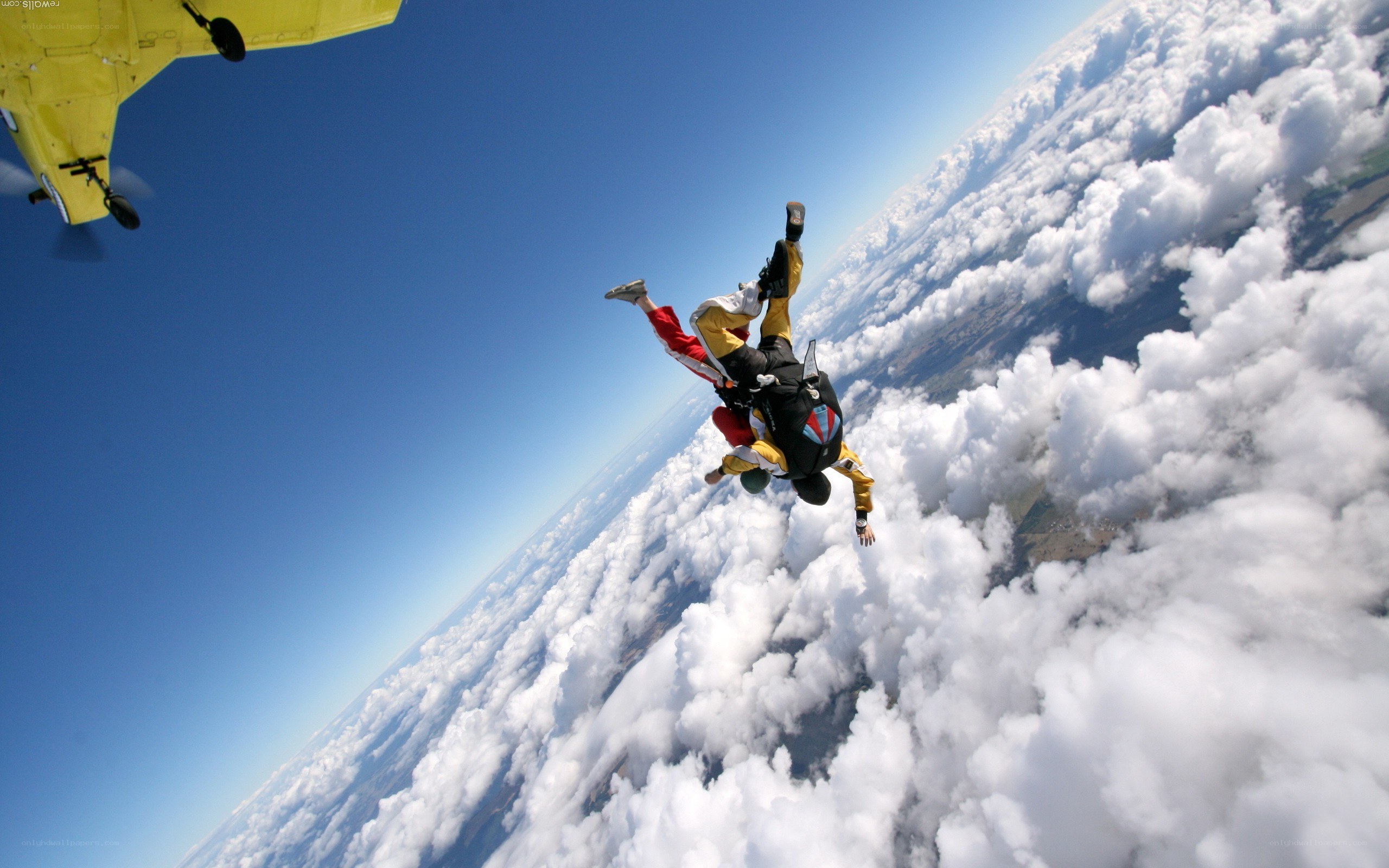 Skydivers above the clouds