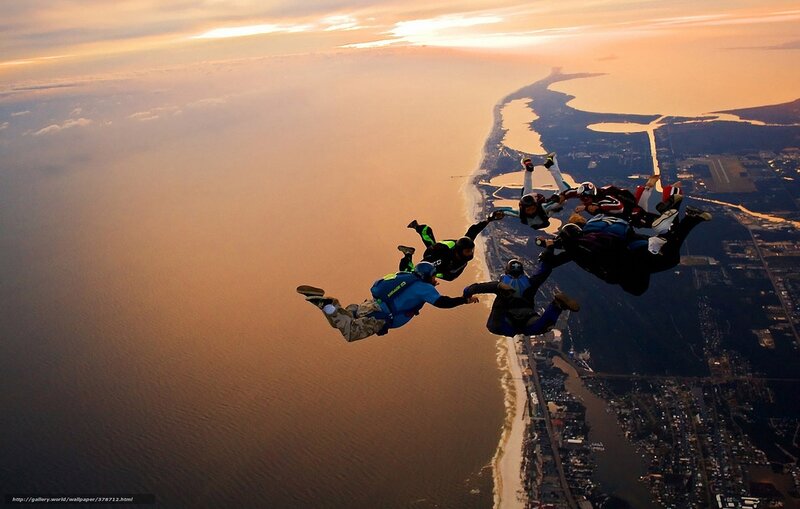 Skydivers in formation at sunset