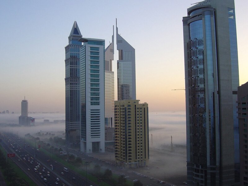 skyscrapers above foggy city