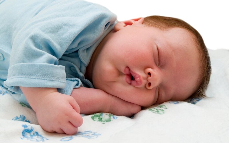 sleeping baby in blue onesie