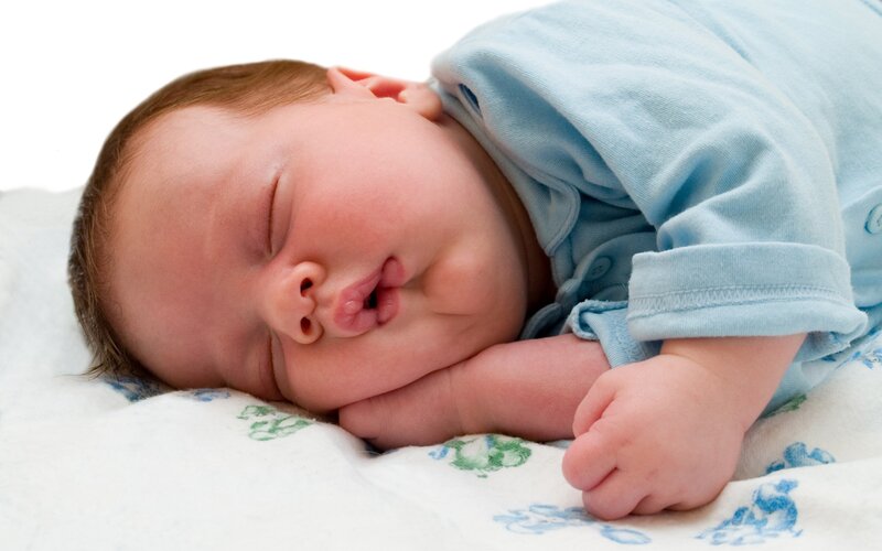 sleeping baby in blue onesie