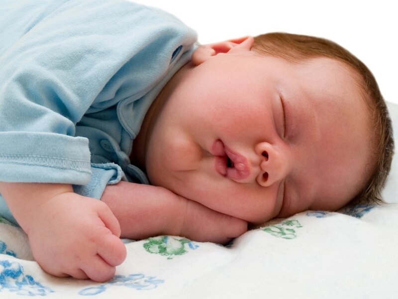 sleeping baby in blue onesie