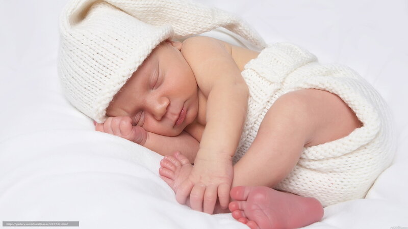 Sleeping baby in white knit outfit
