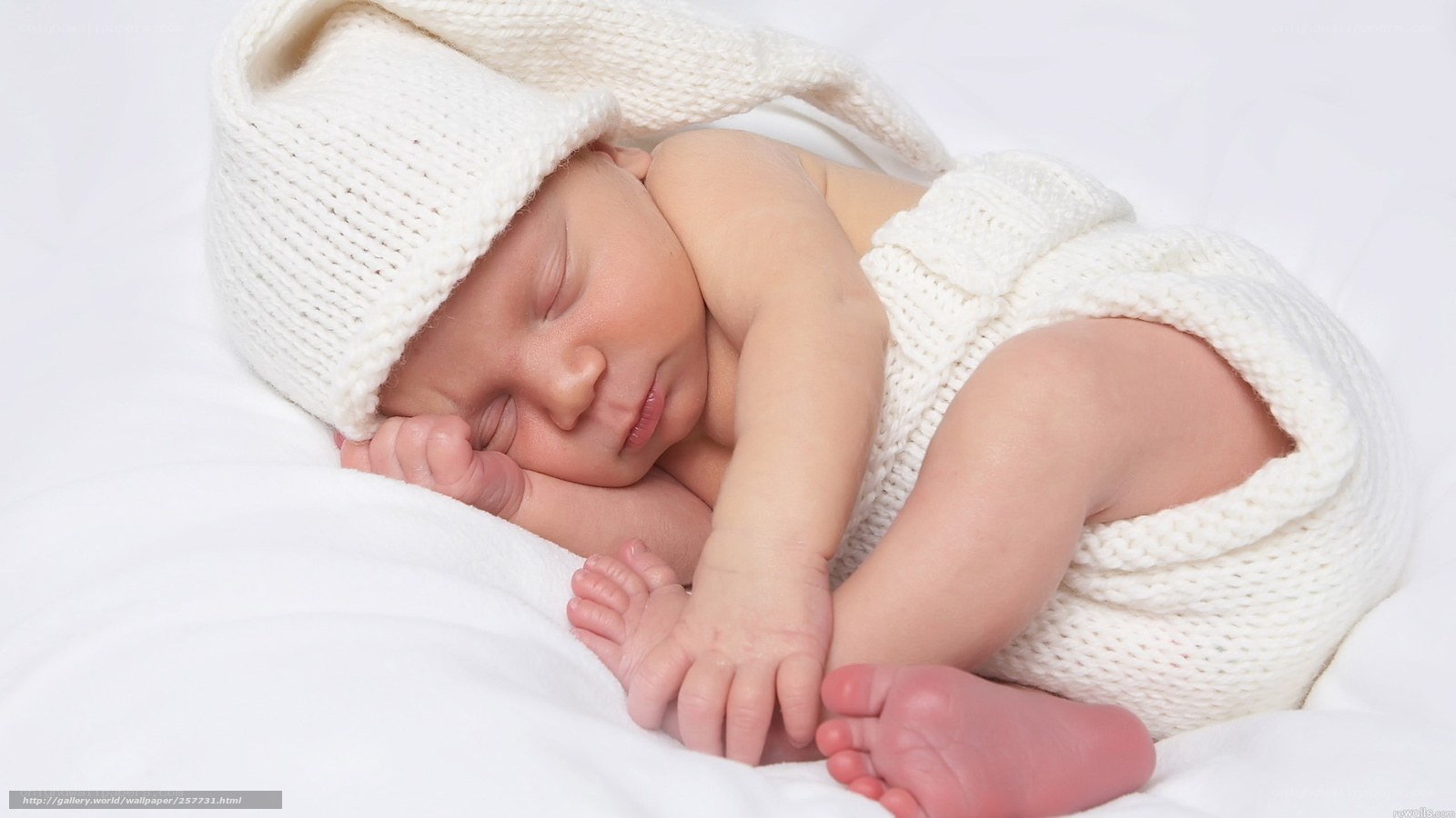 Sleeping baby in white knit outfit