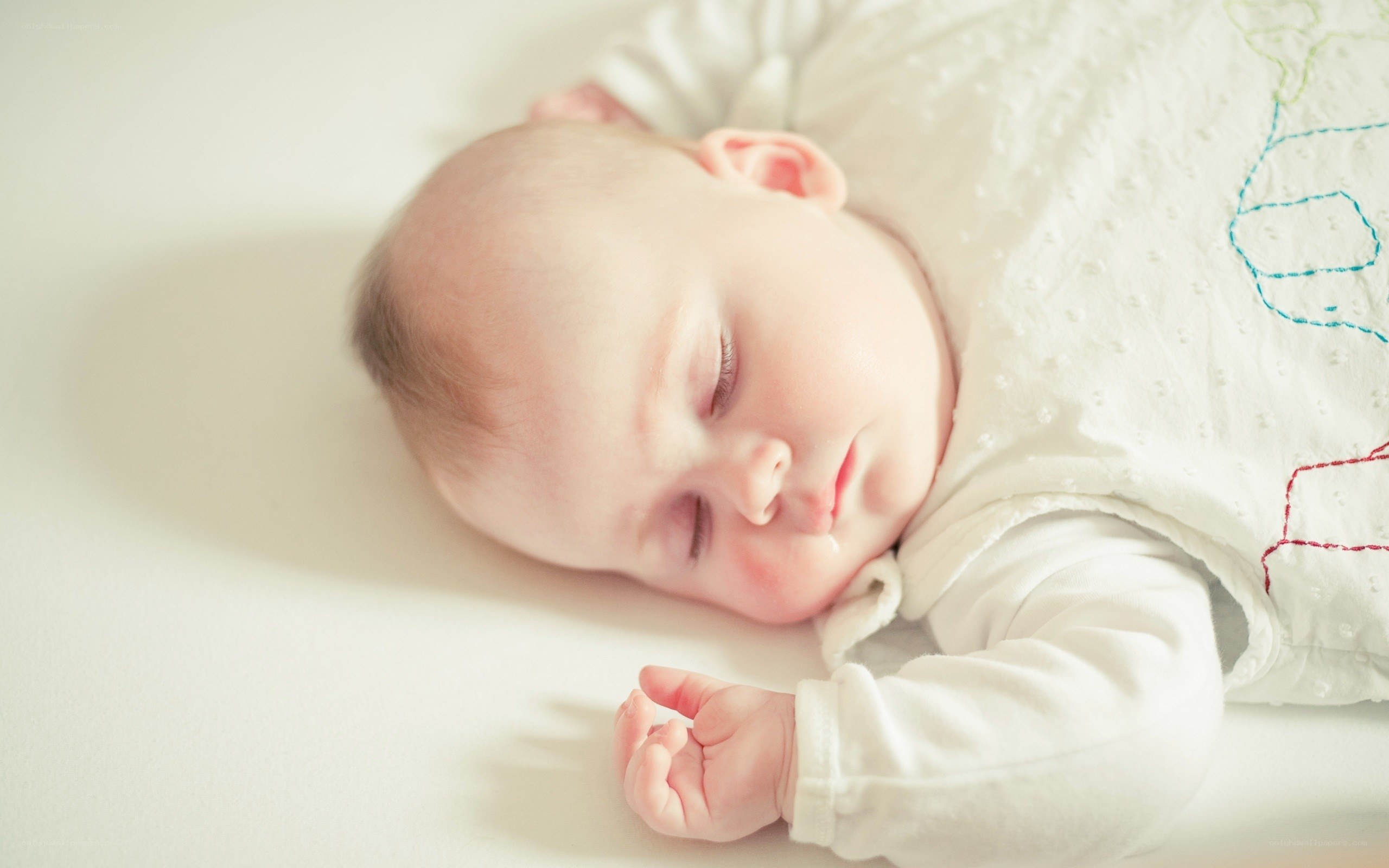 sleeping baby in white onesie