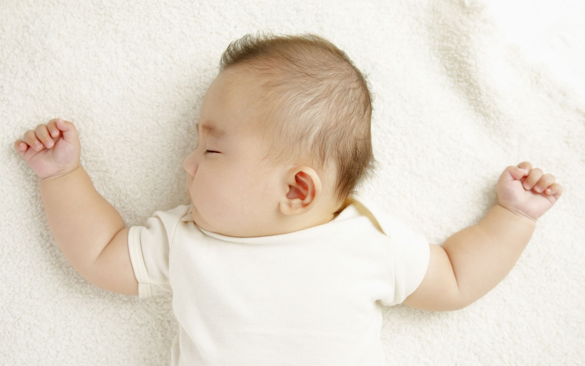 sleeping baby on white blanket