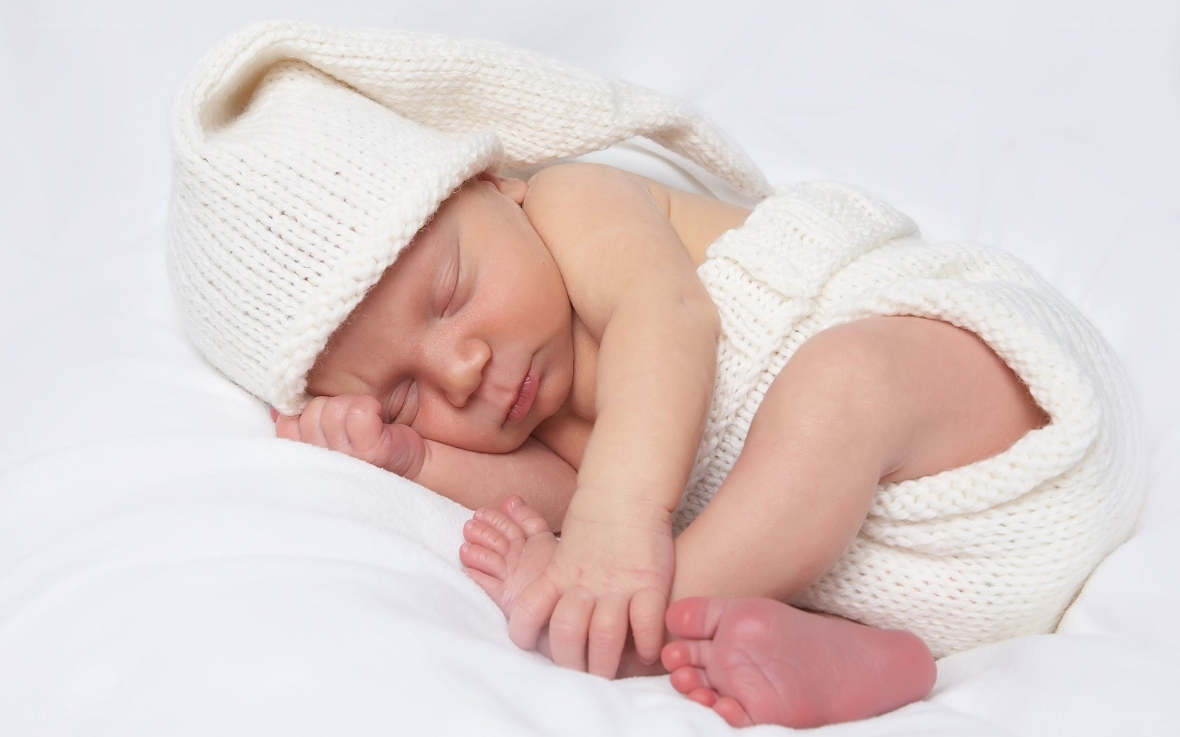 Sleeping newborn in white knit