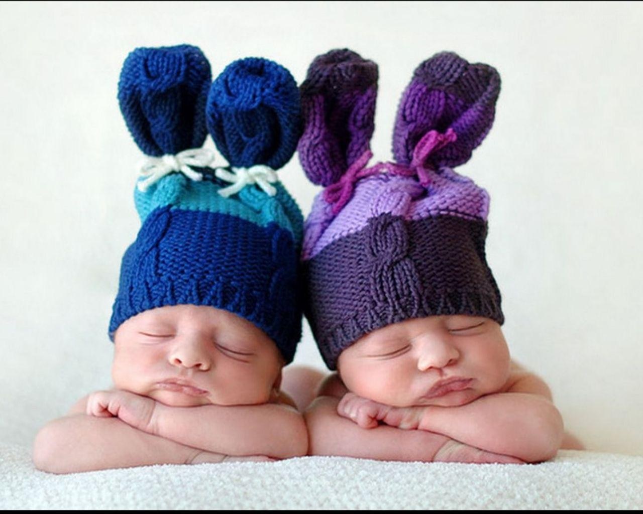 Sleeping newborn twins in hats