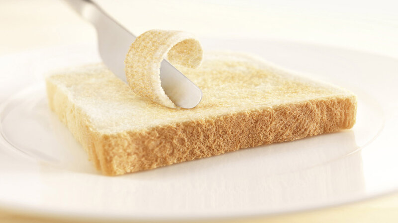 Slice of Bread Being Buttered