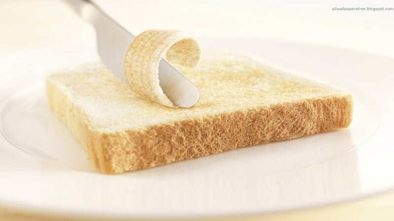 Slice of Bread Being Buttered — White