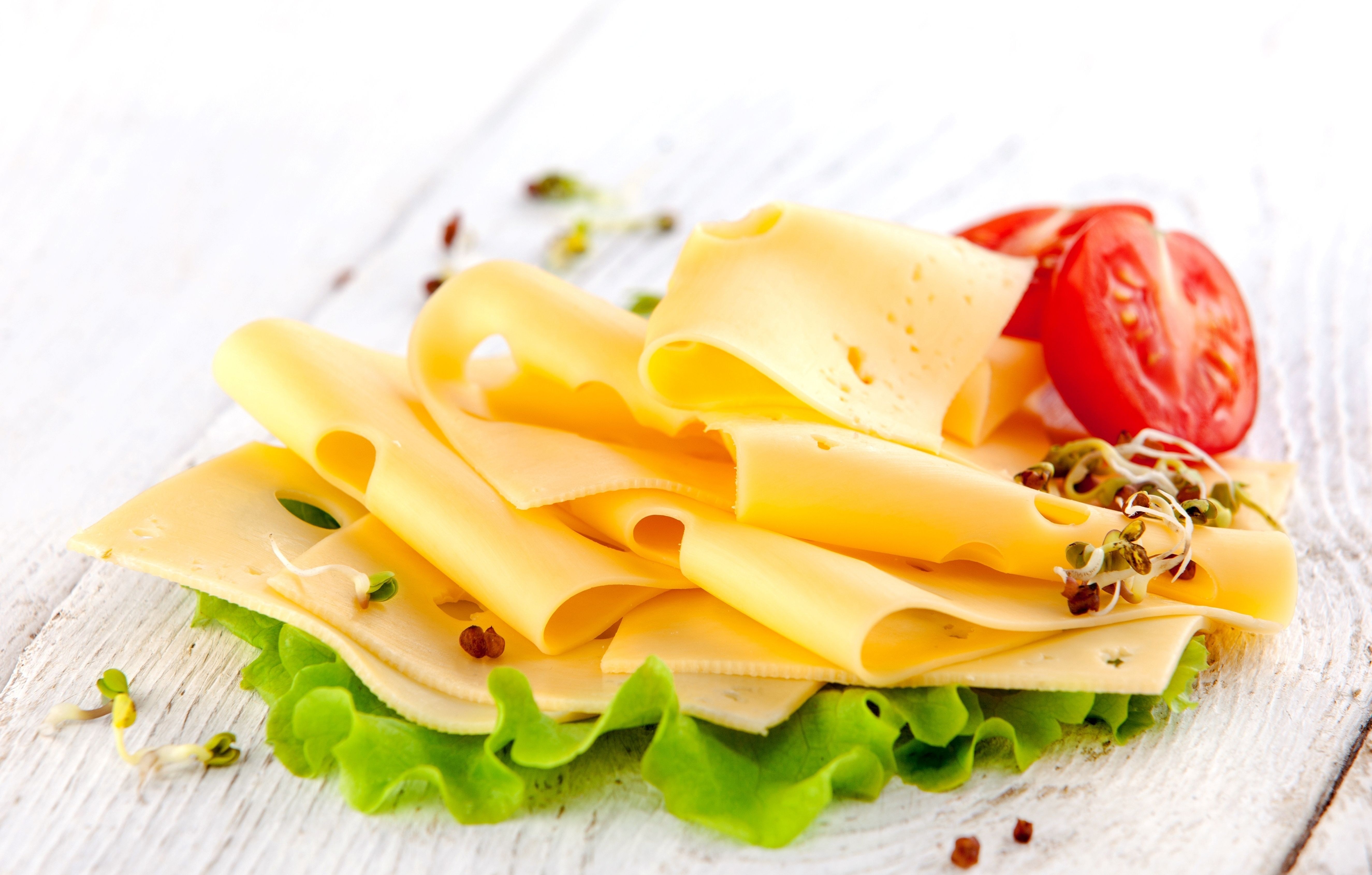 Sliced cheese with tomato and sprouts