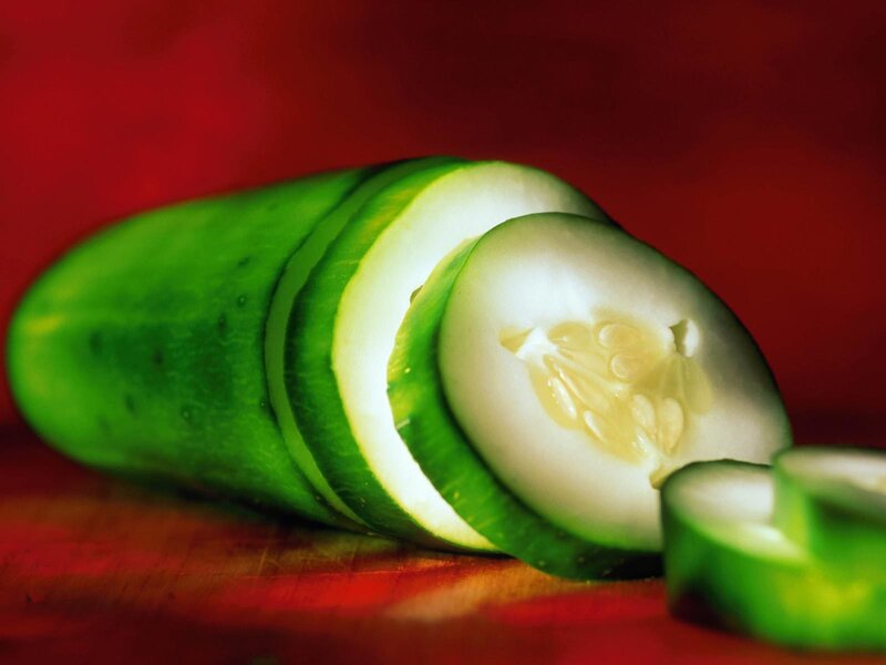 Sliced cucumber on red background