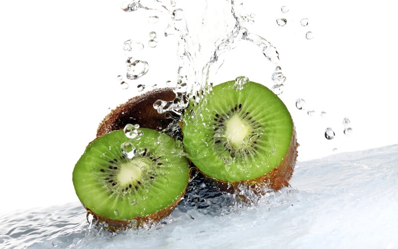 sliced kiwi fruit splashing in water