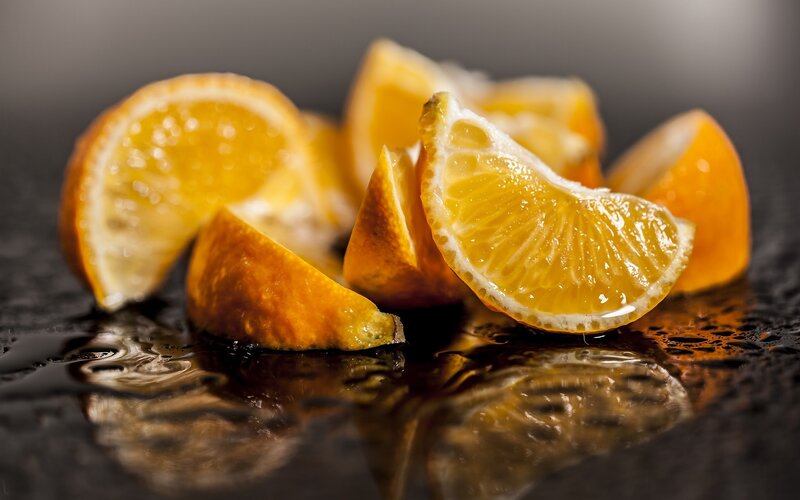 Sliced Oranges on Wet Surface — Orange, Dramatic