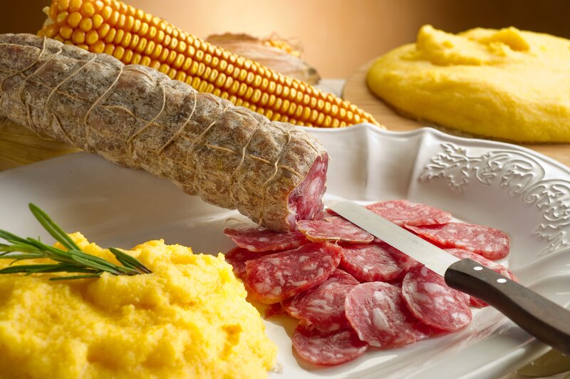 Sliced salami with polenta and corn