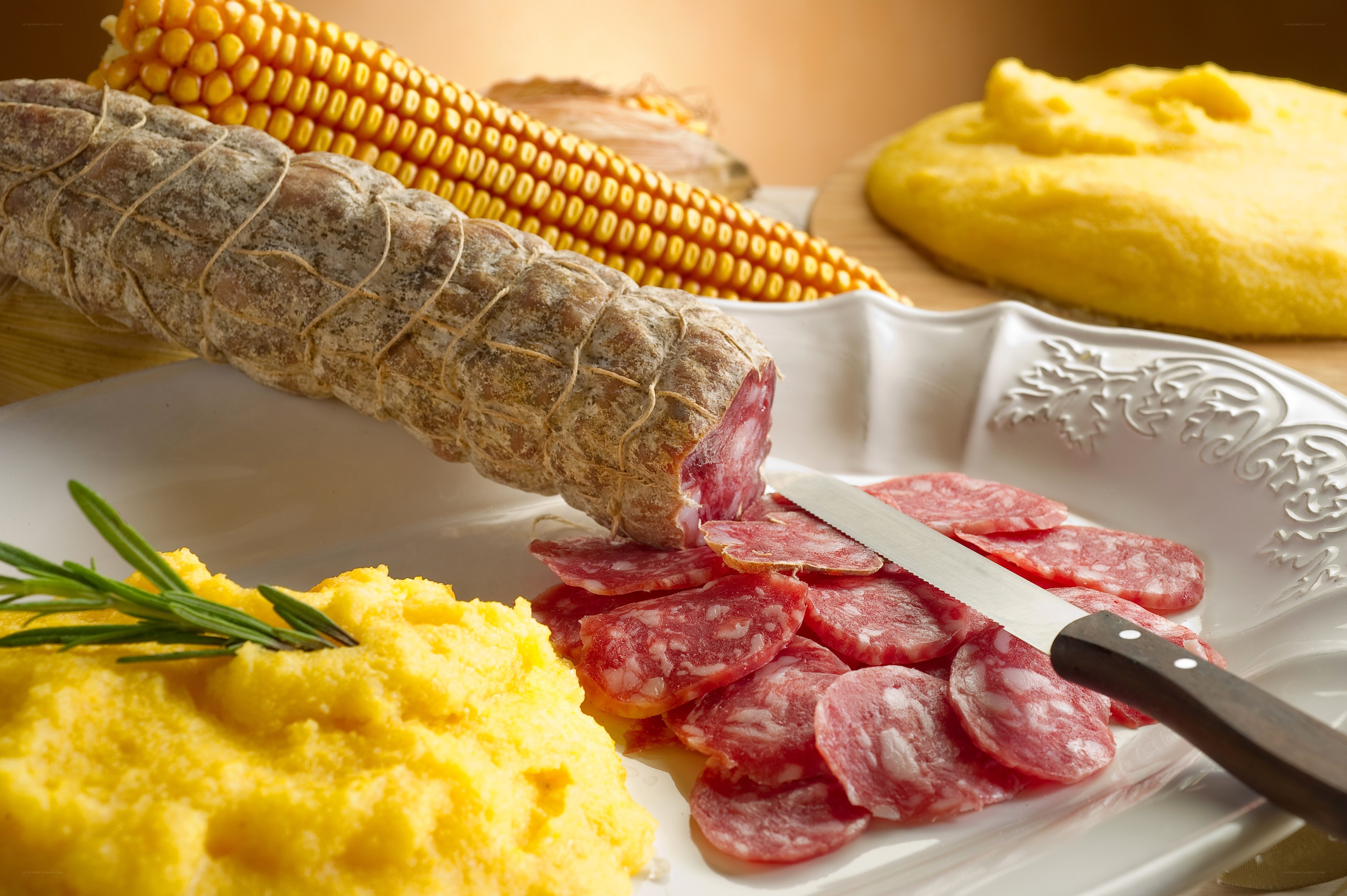 Sliced salami with polenta and corn