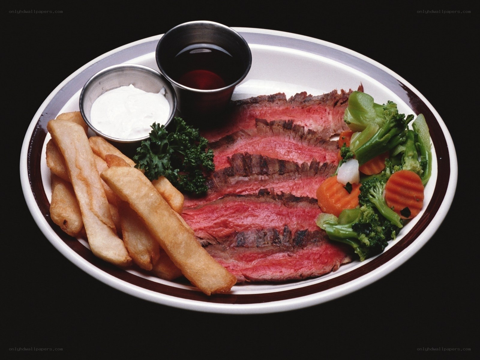 Sliced steak with fries and vegetables