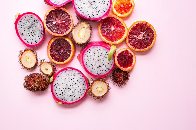 sliced tropical fruits on pink